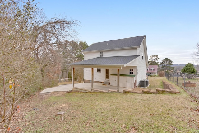 rear view of house featuring central AC unit, a yard, and a patio