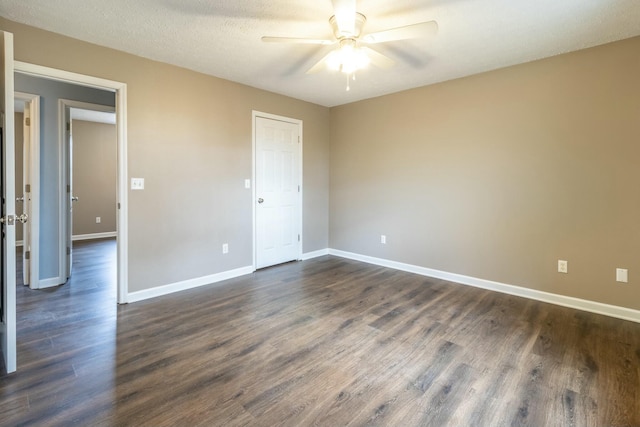 spare room featuring a textured ceiling, ceiling fan, and dark wood-type flooring