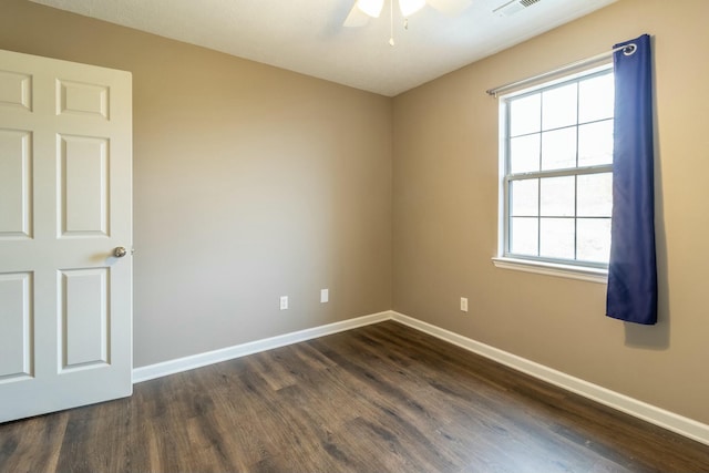 empty room featuring ceiling fan and dark wood-type flooring