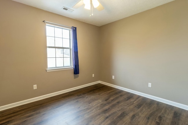 empty room featuring a textured ceiling, dark hardwood / wood-style floors, and ceiling fan