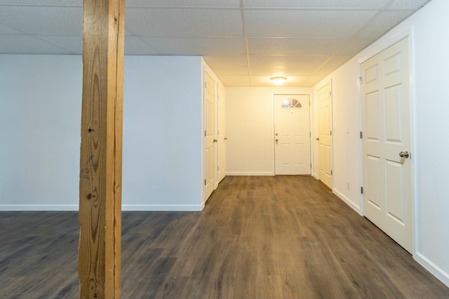 hallway with a paneled ceiling and dark wood-type flooring