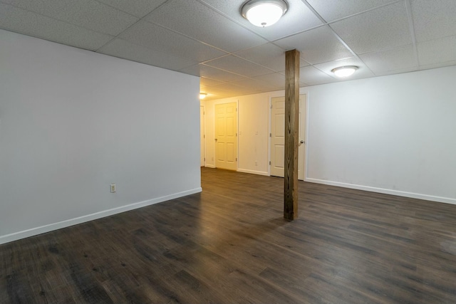 basement with a drop ceiling and dark wood-type flooring