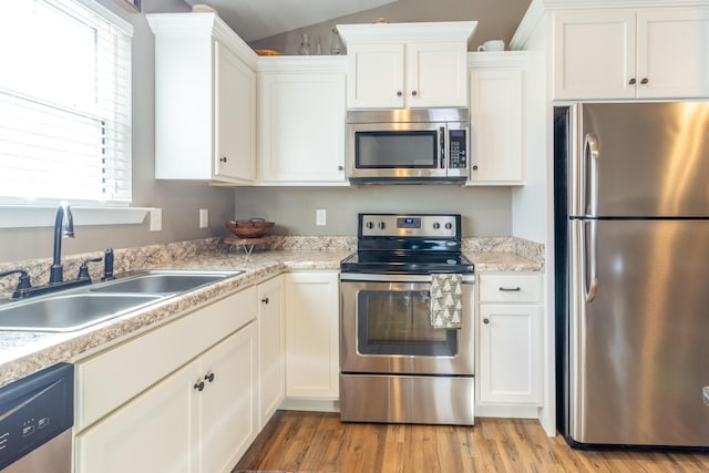 kitchen featuring white cabinetry, sink, light wood-type flooring, and appliances with stainless steel finishes