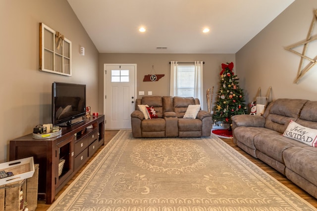 living room with light wood-type flooring and vaulted ceiling