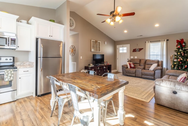 kitchen featuring appliances with stainless steel finishes, ceiling fan, high vaulted ceiling, light hardwood / wood-style floors, and white cabinetry