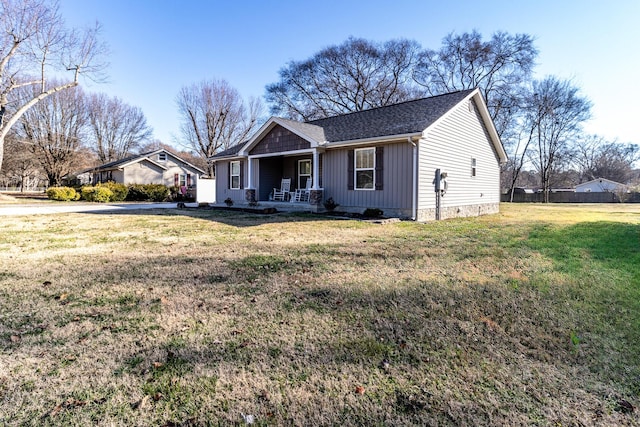 ranch-style house featuring covered porch and a front lawn