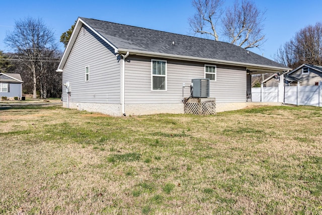 rear view of property with a lawn and central air condition unit