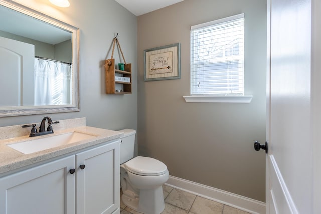 bathroom with tile patterned floors, plenty of natural light, vanity, and toilet