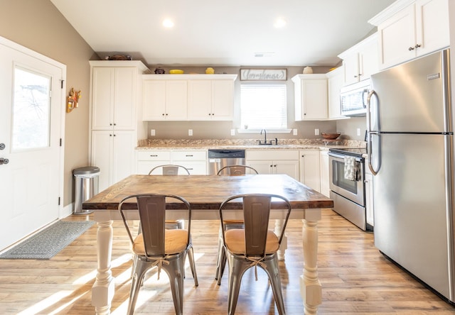 kitchen with stainless steel appliances, white cabinetry, and sink