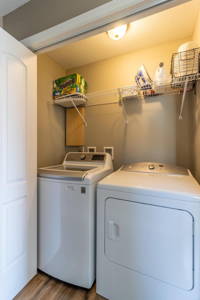 laundry room with washing machine and dryer and hardwood / wood-style flooring