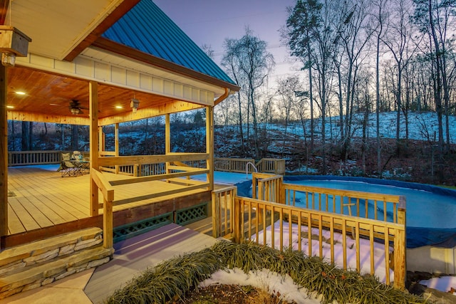 deck at dusk featuring ceiling fan