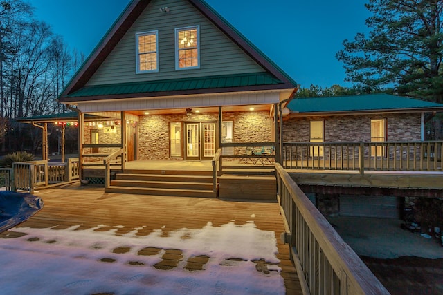 back house at dusk with a garage and a porch