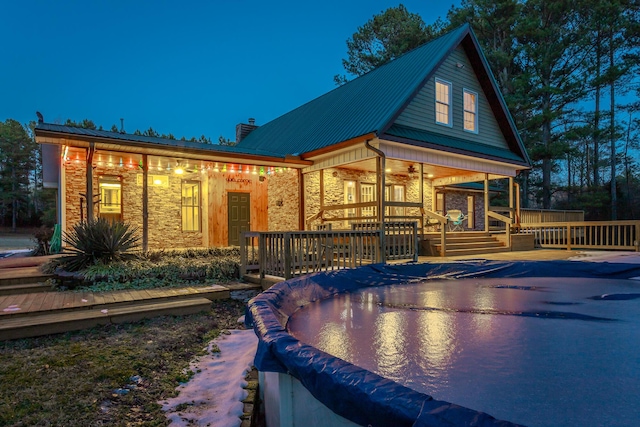 rear view of property featuring a swimming pool side deck