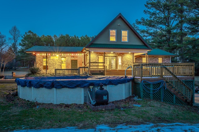 back house at dusk with a covered pool