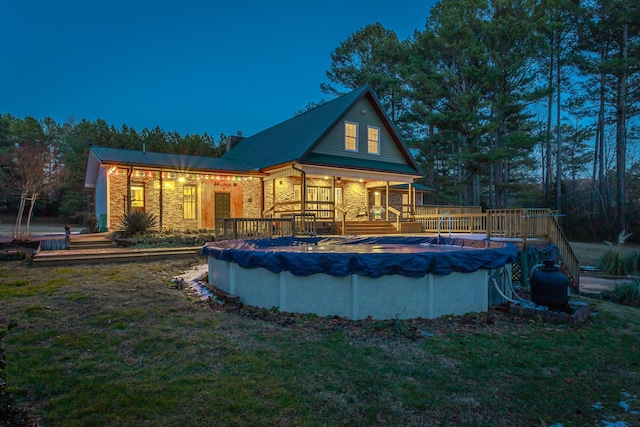 pool at dusk featuring a yard