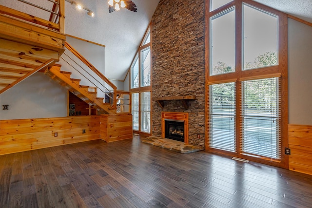 unfurnished living room with high vaulted ceiling, a fireplace, and plenty of natural light