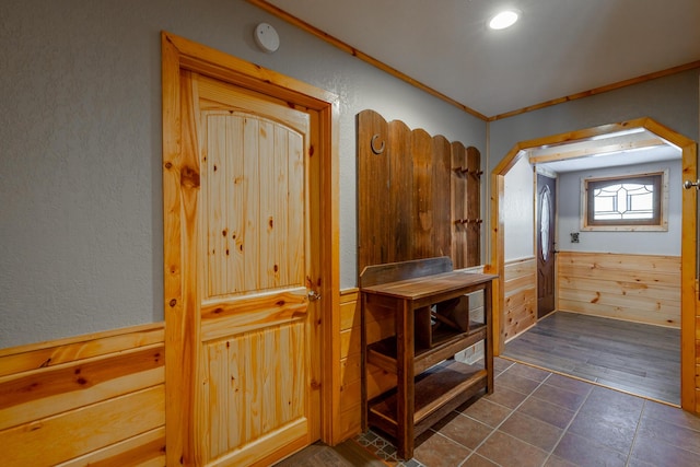 bathroom featuring ornamental molding and wooden walls