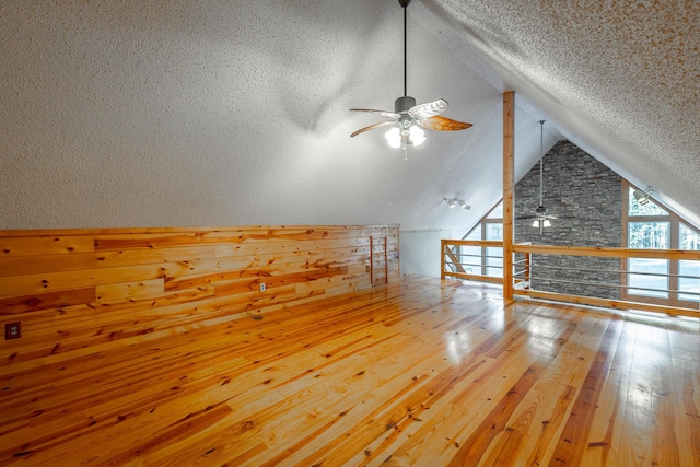 bonus room with ceiling fan, wood-type flooring, a textured ceiling, and lofted ceiling