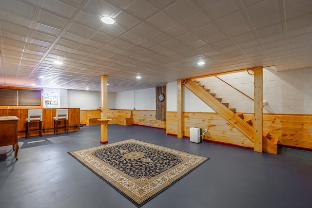 basement featuring wood walls