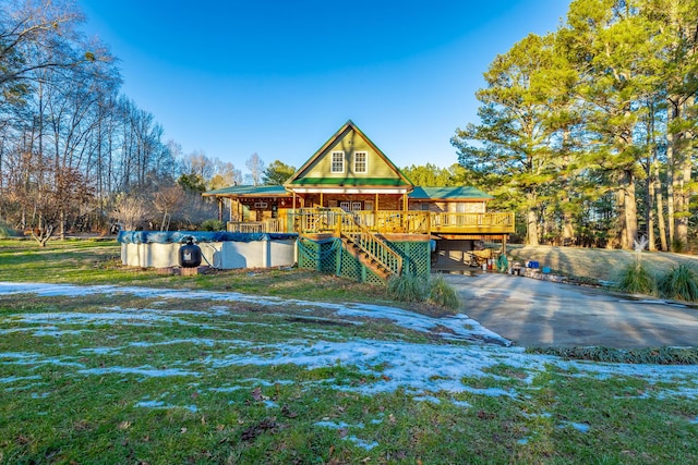 rear view of house featuring a covered pool