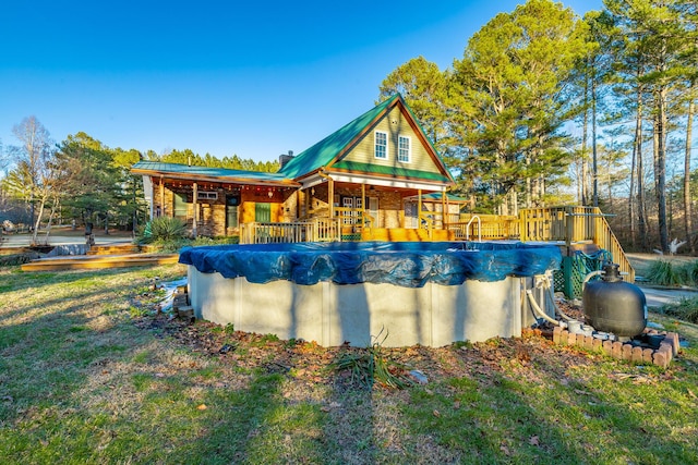 rear view of property with a covered pool