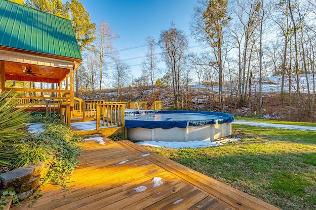 wooden terrace featuring a yard and a covered pool