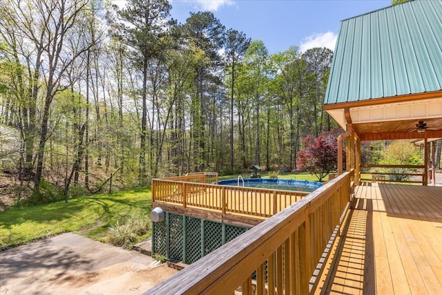 wooden deck with a yard and an outdoor pool