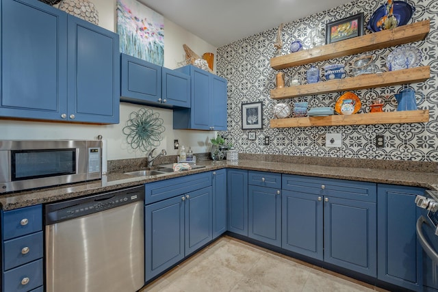 kitchen featuring tasteful backsplash, sink, stainless steel appliances, and blue cabinets