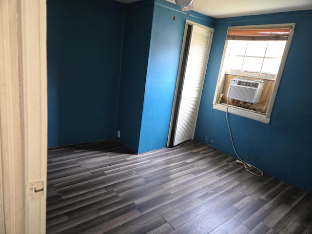 unfurnished room with cooling unit and dark hardwood / wood-style floors