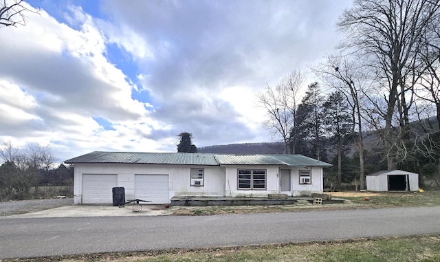 single story home with a garage and a storage shed