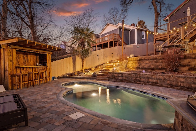 pool at dusk with a bar and a patio