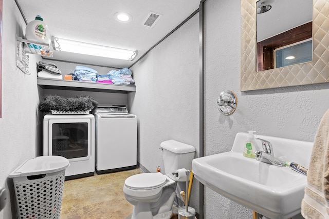 bathroom with washer and dryer, toilet, and sink