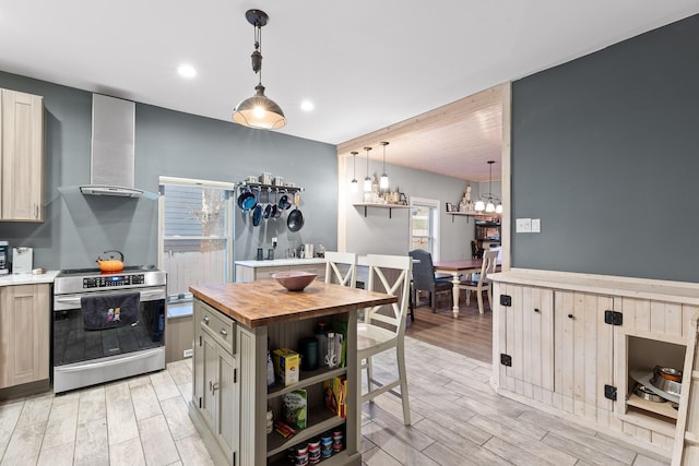 kitchen featuring wood counters, pendant lighting, stainless steel electric range, a kitchen island, and light wood-type flooring