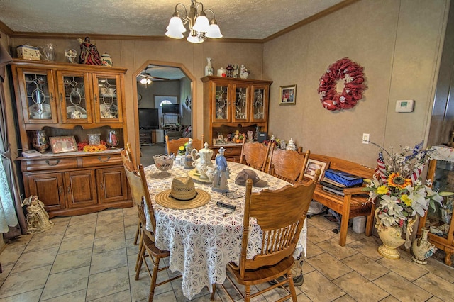 dining room featuring ornamental molding, a textured ceiling, and an inviting chandelier