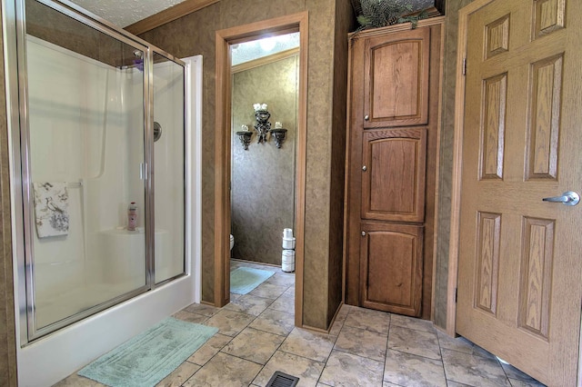 bathroom with crown molding, toilet, a textured ceiling, and walk in shower