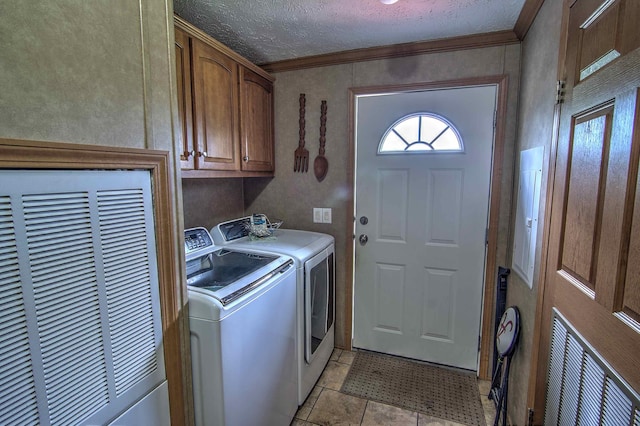 clothes washing area featuring cabinets, washing machine and dryer, crown molding, a textured ceiling, and light tile patterned floors