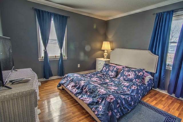 bedroom featuring a textured ceiling, ornamental molding, and hardwood / wood-style floors