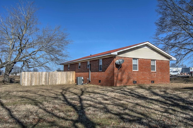 rear view of house featuring central AC and a yard