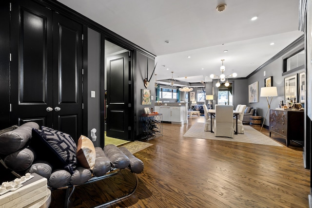 living room featuring hardwood / wood-style floors, a notable chandelier, and crown molding