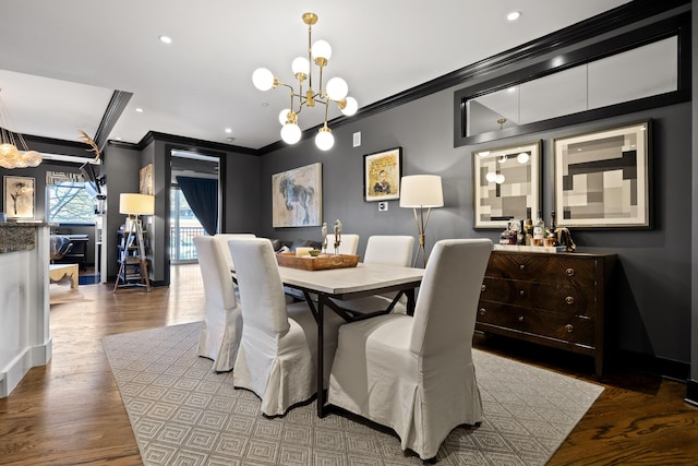 dining room with a chandelier, hardwood / wood-style floors, and crown molding