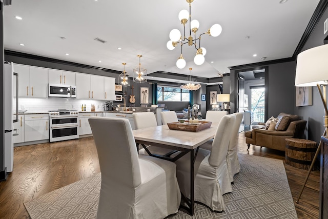 dining area featuring crown molding, plenty of natural light, dark hardwood / wood-style floors, and a notable chandelier