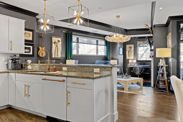 kitchen with white cabinetry, hanging light fixtures, and dark stone counters