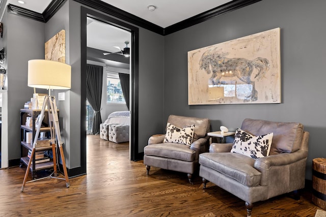 living area featuring dark hardwood / wood-style flooring, ceiling fan, and ornamental molding