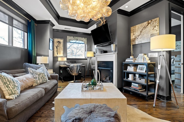 living room with a chandelier, dark hardwood / wood-style flooring, and crown molding