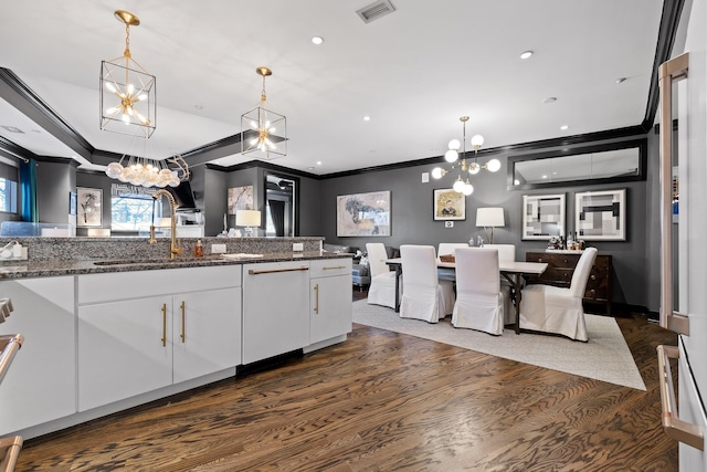 kitchen with white cabinetry, dishwasher, sink, hanging light fixtures, and dark stone countertops