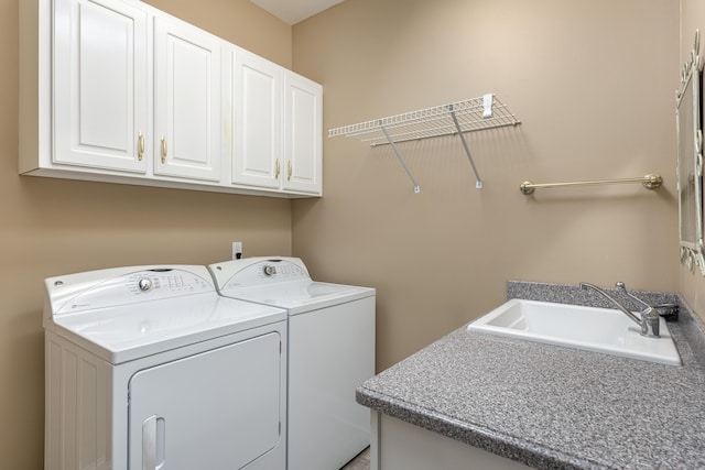 washroom with cabinets, separate washer and dryer, and sink