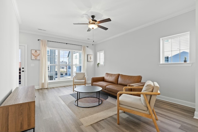 living room featuring light hardwood / wood-style floors, ceiling fan, and crown molding