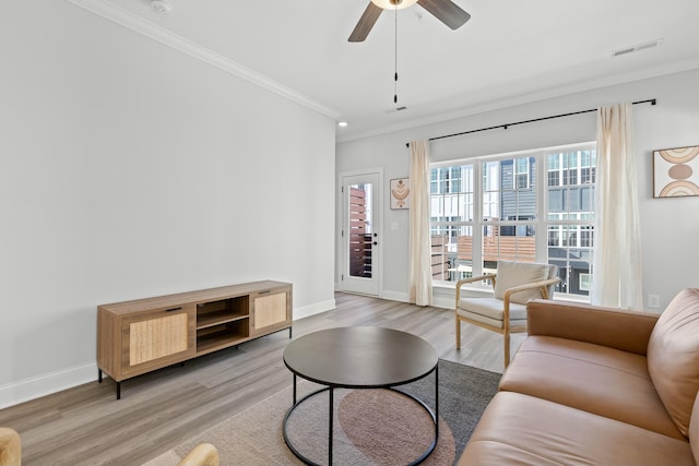 living room with light wood-type flooring, ceiling fan, and crown molding