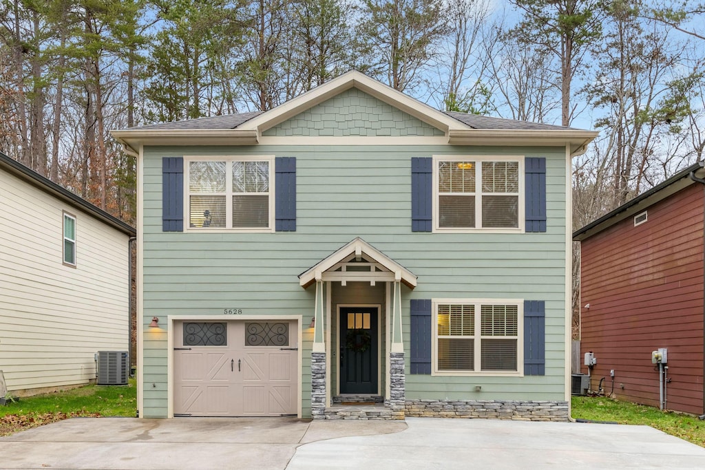 craftsman-style home featuring a garage and central air condition unit