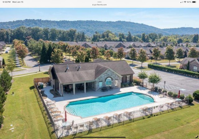 view of swimming pool featuring a patio, a yard, and a mountain view